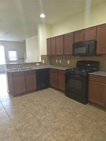 a kitchen with stainless steel appliances granite countertop a sink and a stove