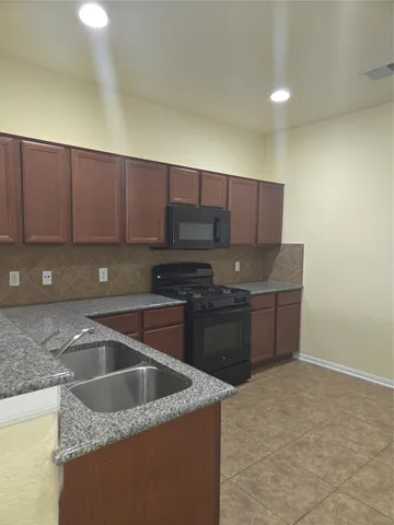 a kitchen with a sink a stove and cabinets