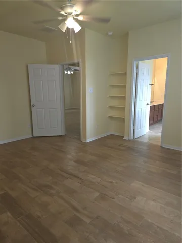 an empty room with closet and wooden floor