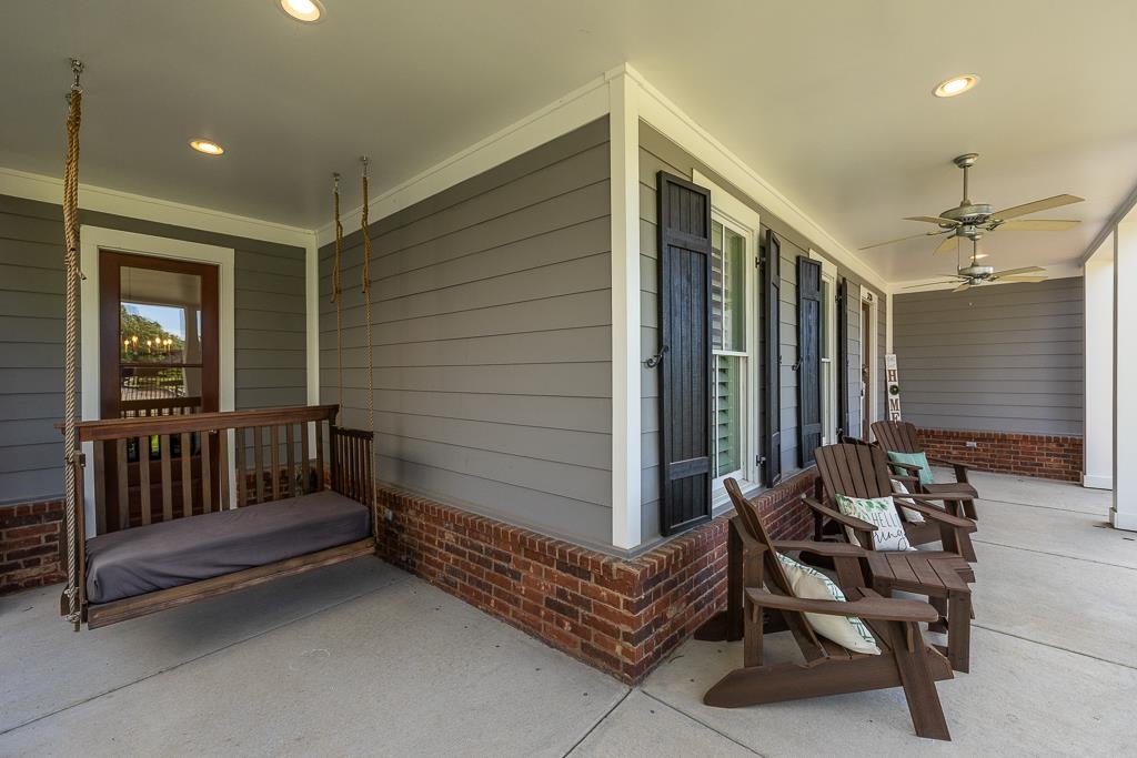 328 Washington Street Collierville, TN 38017 - Photo 5 of 33 Expansive covered porch featuring a brick foundation, gray horizontal siding, white trim, and two ceiling fans