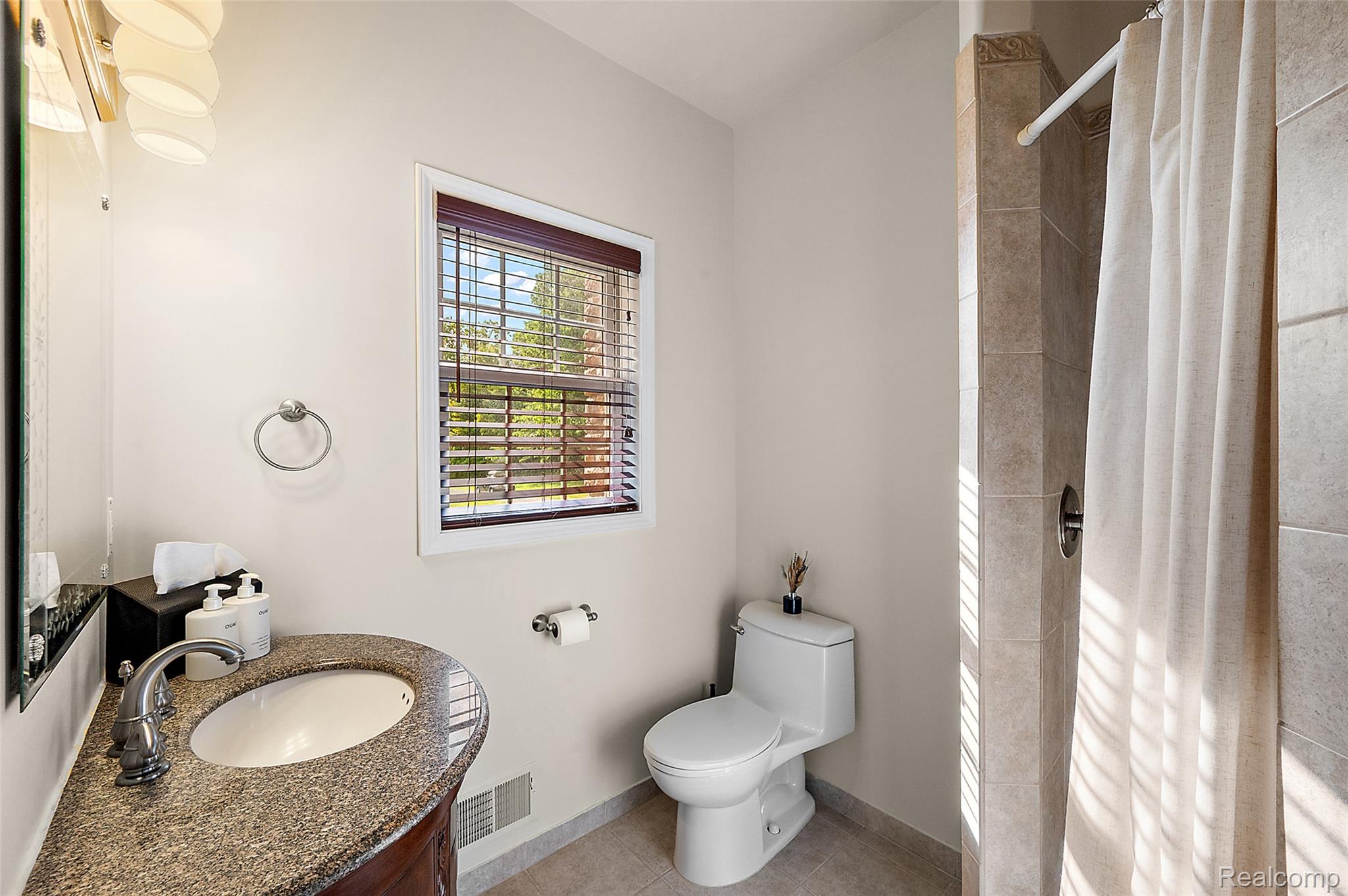 5035 Hidden Ridge Road Metamora, MI 48455 - Photo 24 of 65 Bathroom with granite countertop vanity, integrated sink, and wood-finish cabinetry
