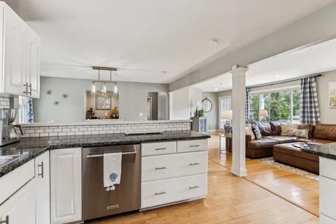 a spacious bathroom with a granite countertop sink a mirror and a bathtub
