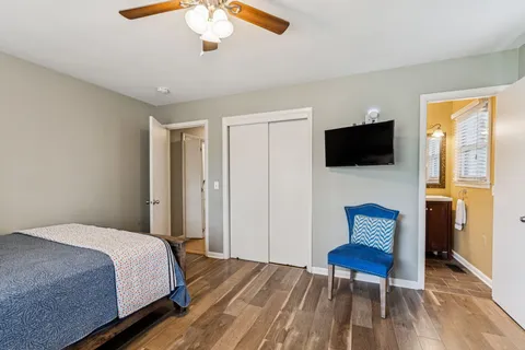 a bedroom with a bed tv and a window