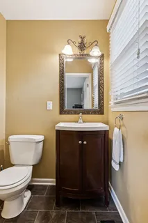 a bathroom with a toilet a sink and mirror