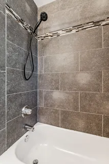 a bathroom with a bath tub with white shower