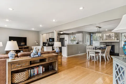 a living room with furniture a flat screen tv and a dining table