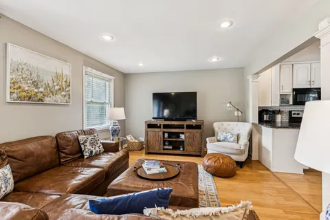 a living room with furniture a flat screen tv and a window