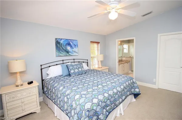 a bedroom with a large bed and a chandelier