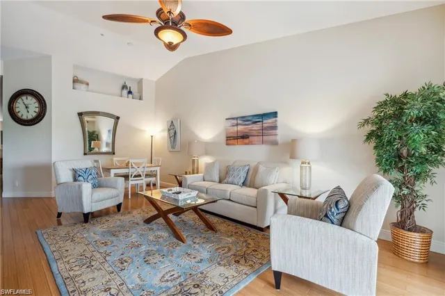 a living room with furniture a rug and a clock