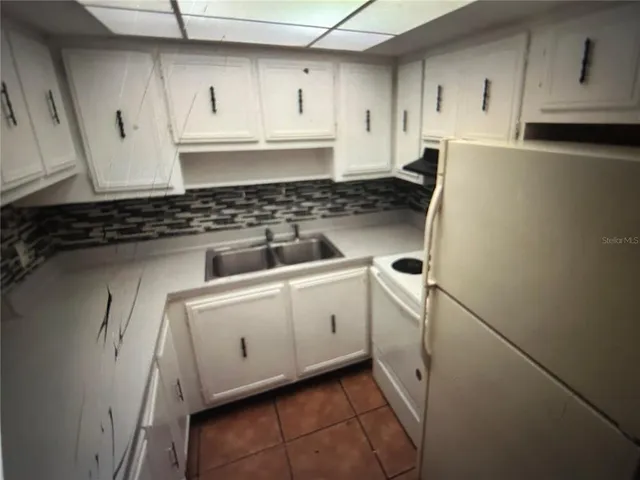 a kitchen with white cabinets and white appliances