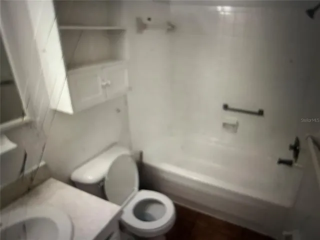 a white toilet sitting next to a bath tub