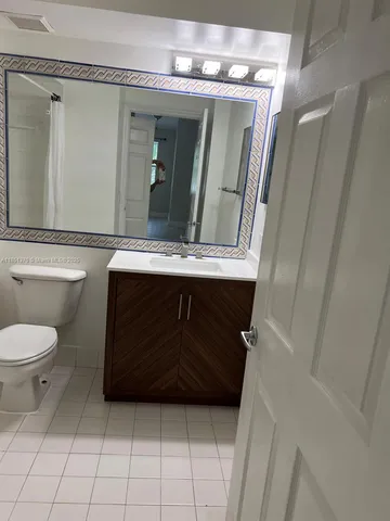a kitchen with kitchen island white cabinets and refrigerator
