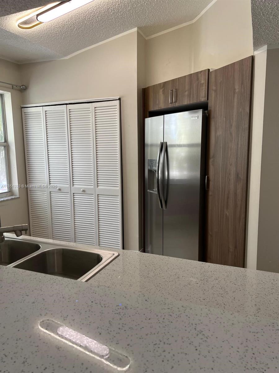 9645 Northwest 1st Court, Unit 1209 Pembroke Pines, FL 33024 - Photo 15 of 70 a kitchen with kitchen island white cabinets and refrigerator