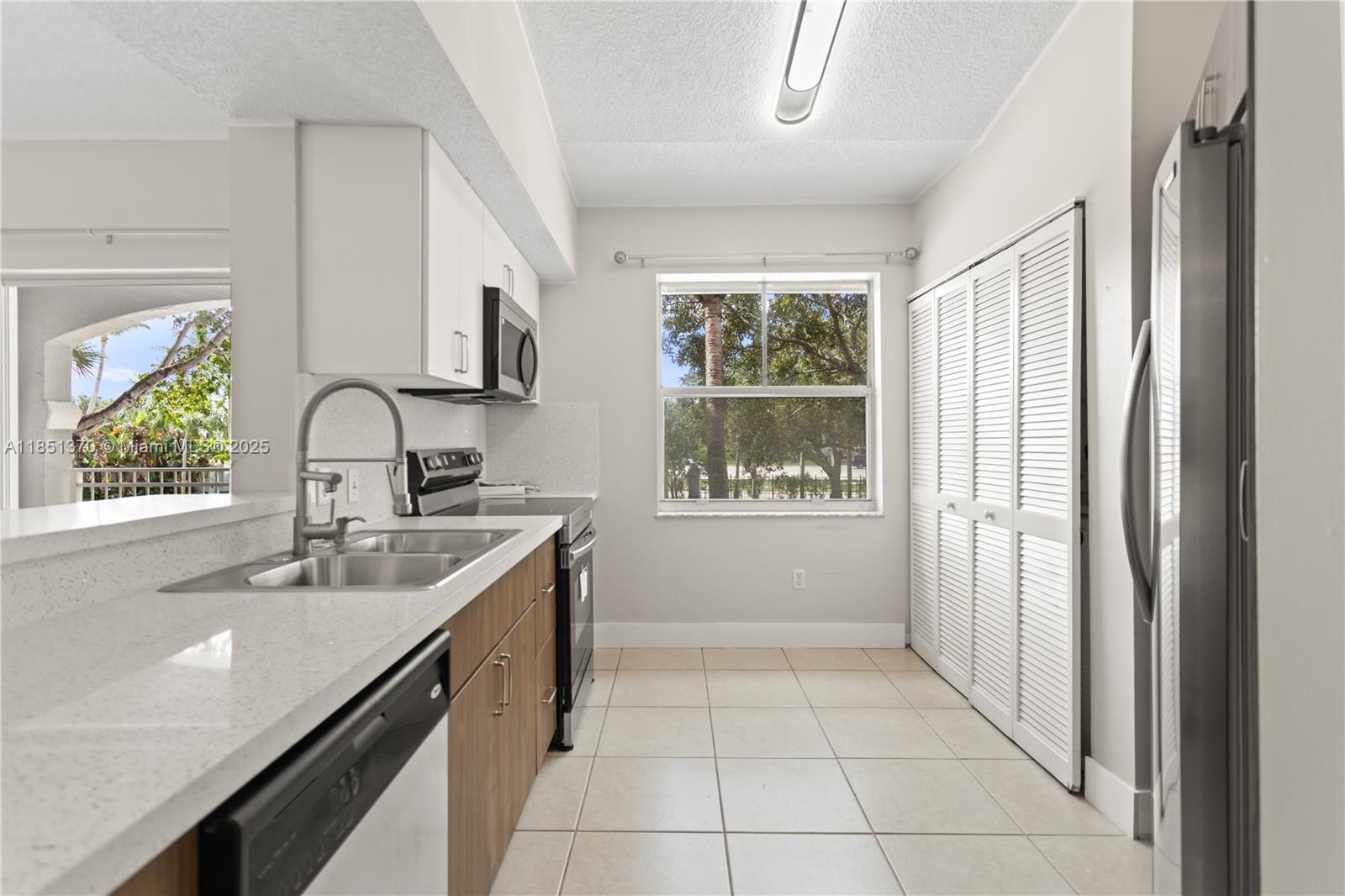 9645 Northwest 1st Court, Unit 1209 Pembroke Pines, FL 33024 - Photo 31 of 70 a kitchen with a sink cabinets and window