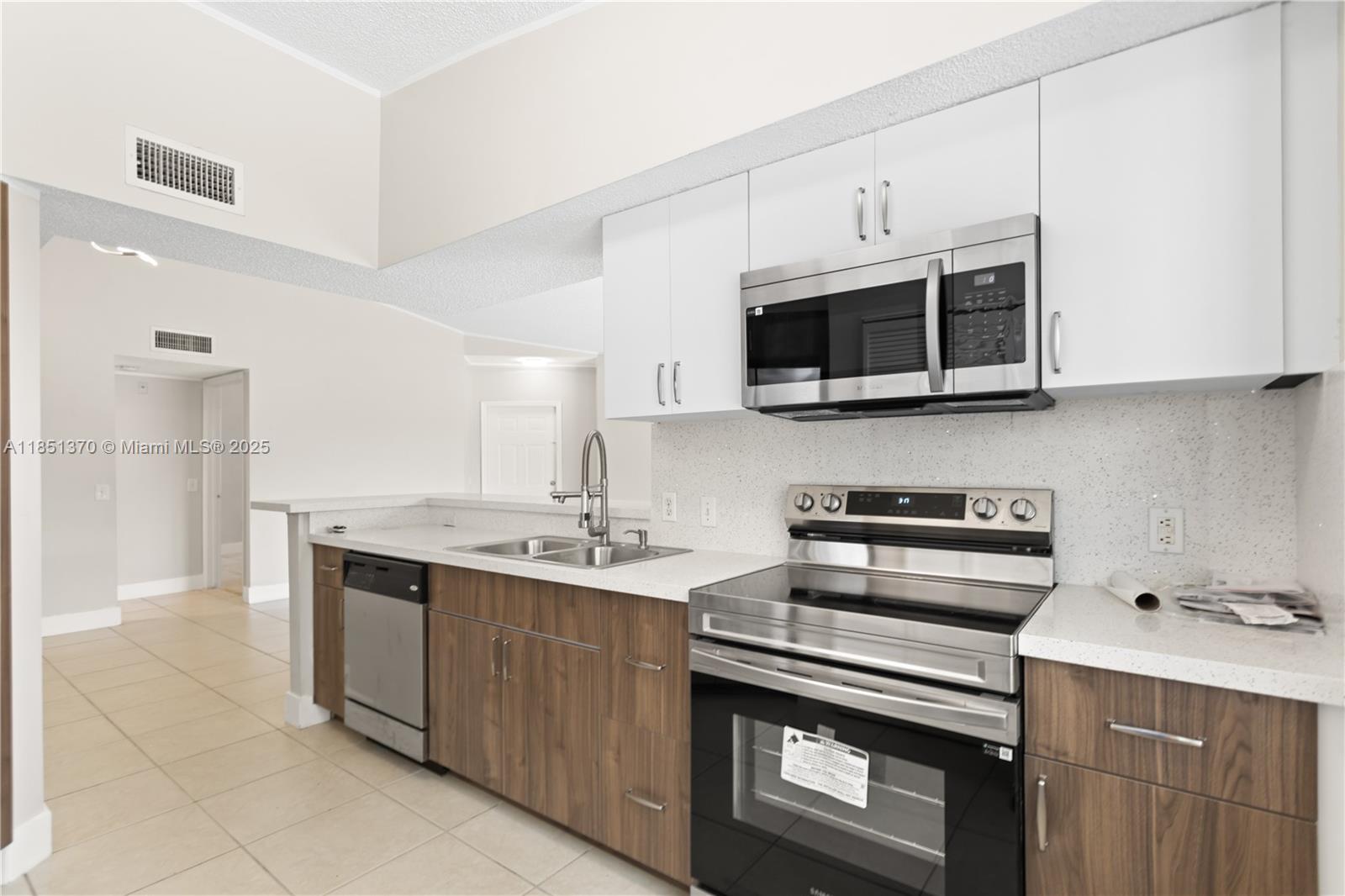 9645 Northwest 1st Court, Unit 1209 Pembroke Pines, FL 33024 - Photo 34 of 70 a kitchen with stainless steel appliances a stove a sink and a microwave