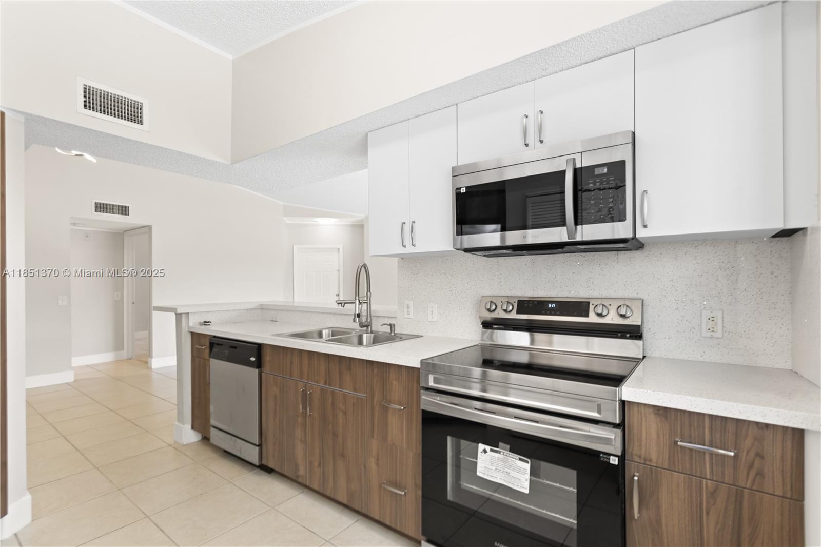9645 Northwest 1st Court, Unit 1209 Pembroke Pines, FL 33024 - Photo 35 of 70 a kitchen with stainless steel appliances a stove a microwave and cabinets