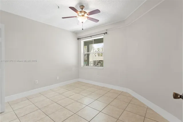 a view of an empty room with a ceiling fan