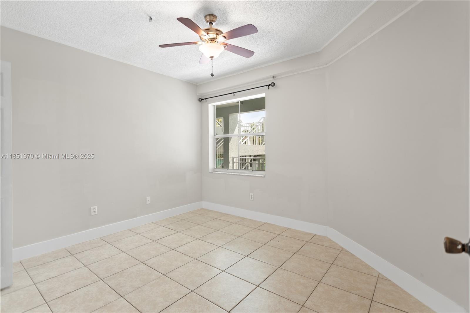 9645 Northwest 1st Court, Unit 1209 Pembroke Pines, FL 33024 - Photo 38 of 70 an empty room with a chandelier fan and windows