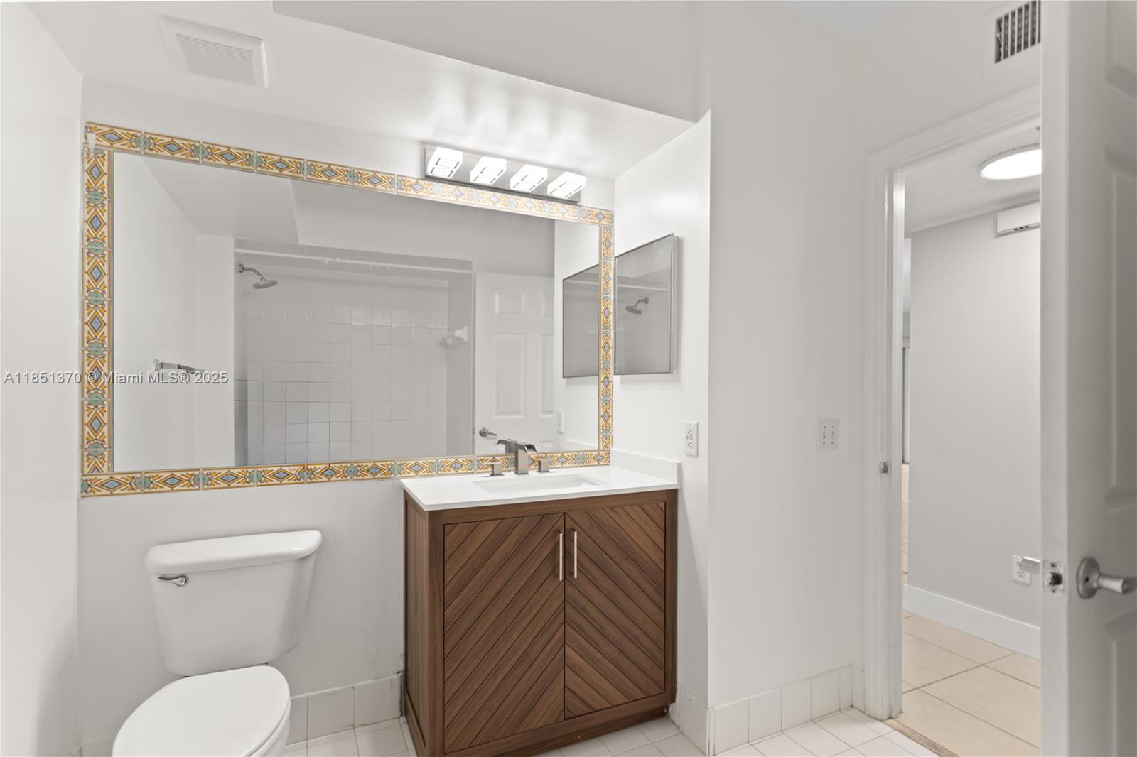 9645 Northwest 1st Court, Unit 1209 Pembroke Pines, FL 33024 - Photo 46 of 70 a bathroom with a sink a toilet and a mirror