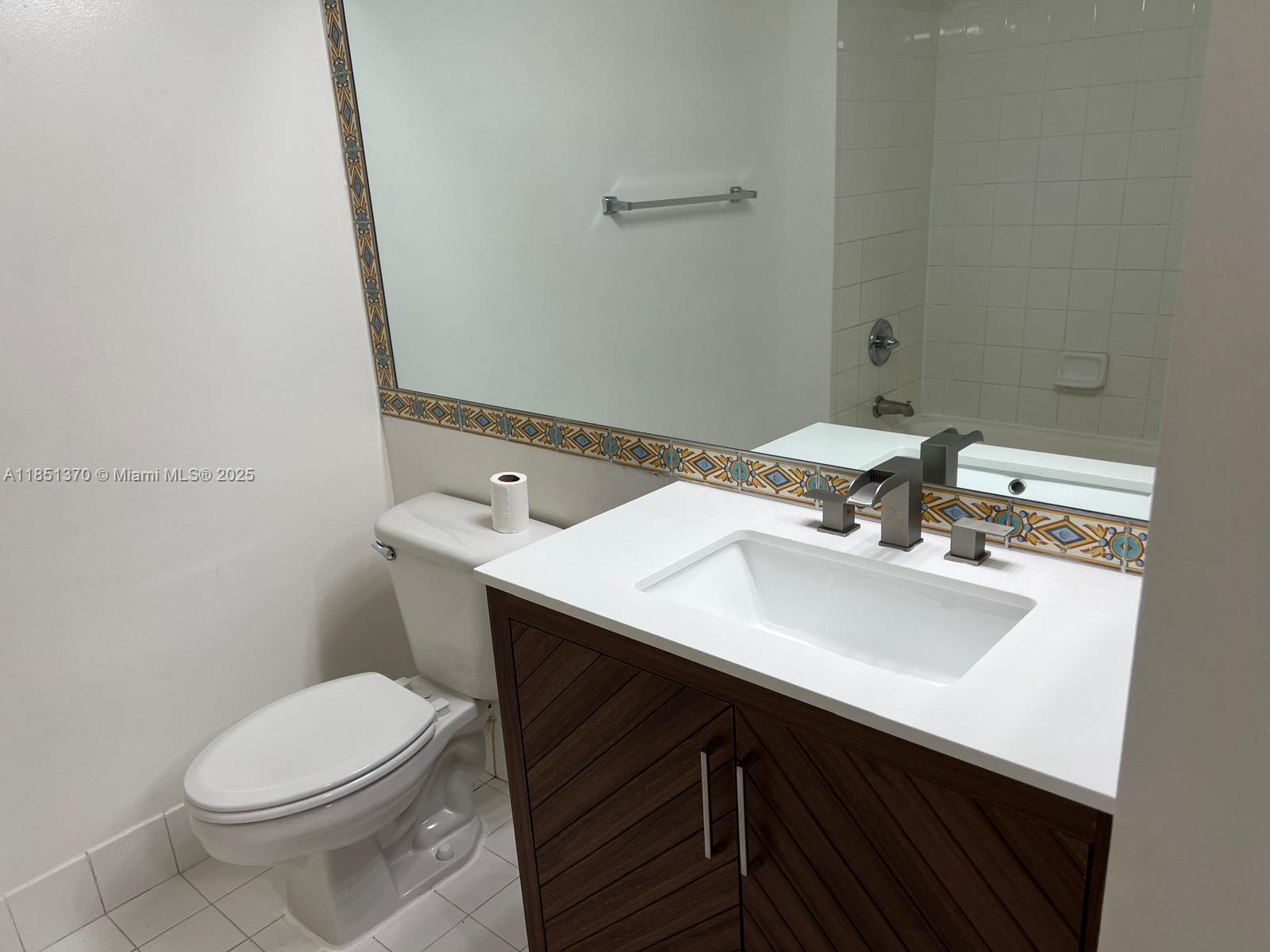 9645 Northwest 1st Court, Unit 1209 Pembroke Pines, FL 33024 - Photo 10 of 70 a bathroom with a sink a toilet and mirror