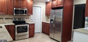 77 Fieldstone Road Levittown, PA 19056 - Photo 2 of 5 a kitchen with stainless steel appliances granite countertop a refrigerator and a microwave