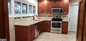 77 Fieldstone Road Levittown, PA 19056 - Photo 3 of 5 a kitchen with a sink stove and microwave
