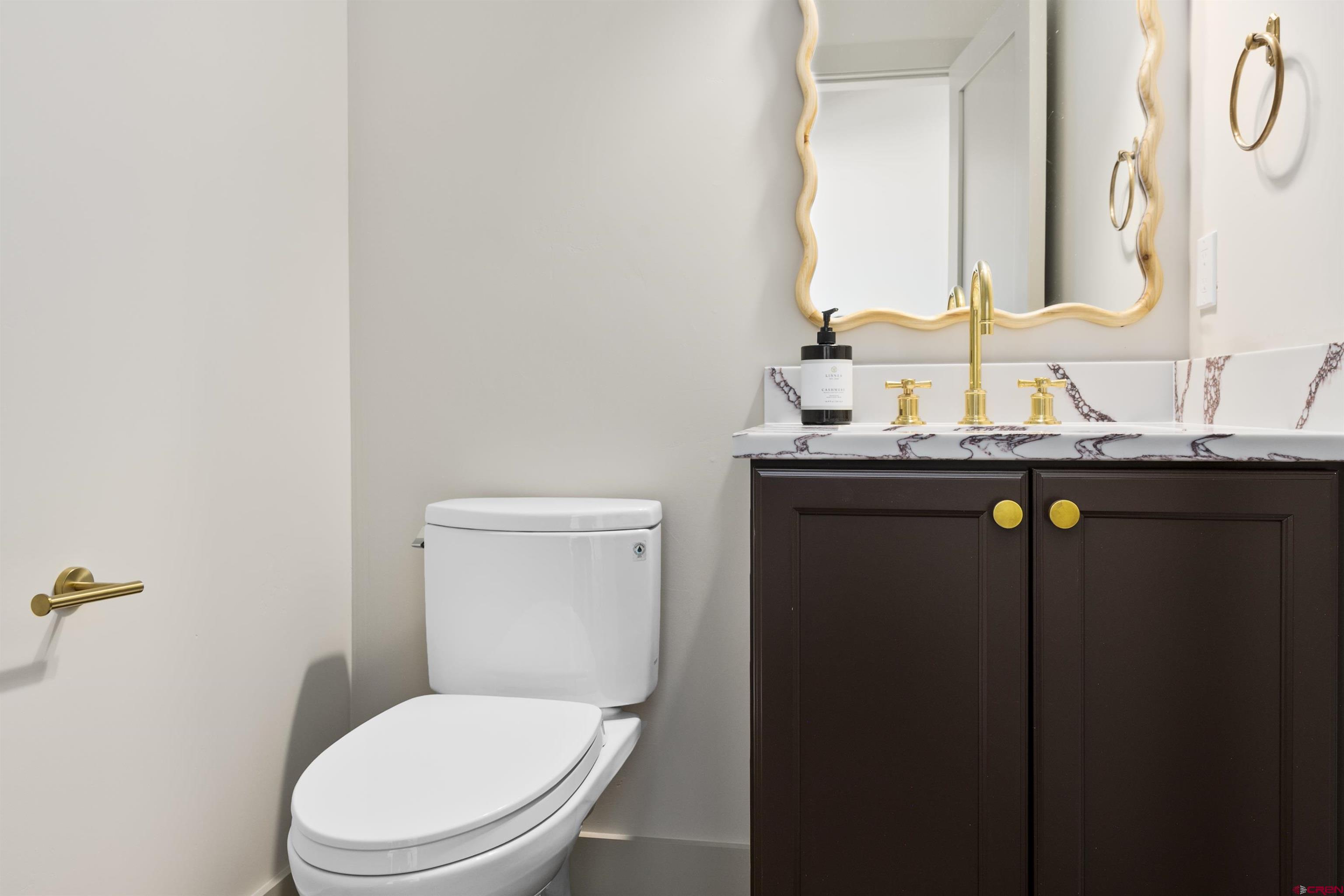 180 Elk Valley Road, Unit 118 Crested Butte, CO 81224 - Photo 16 of 39 a bathroom with a granite countertop toilet sink and mirror