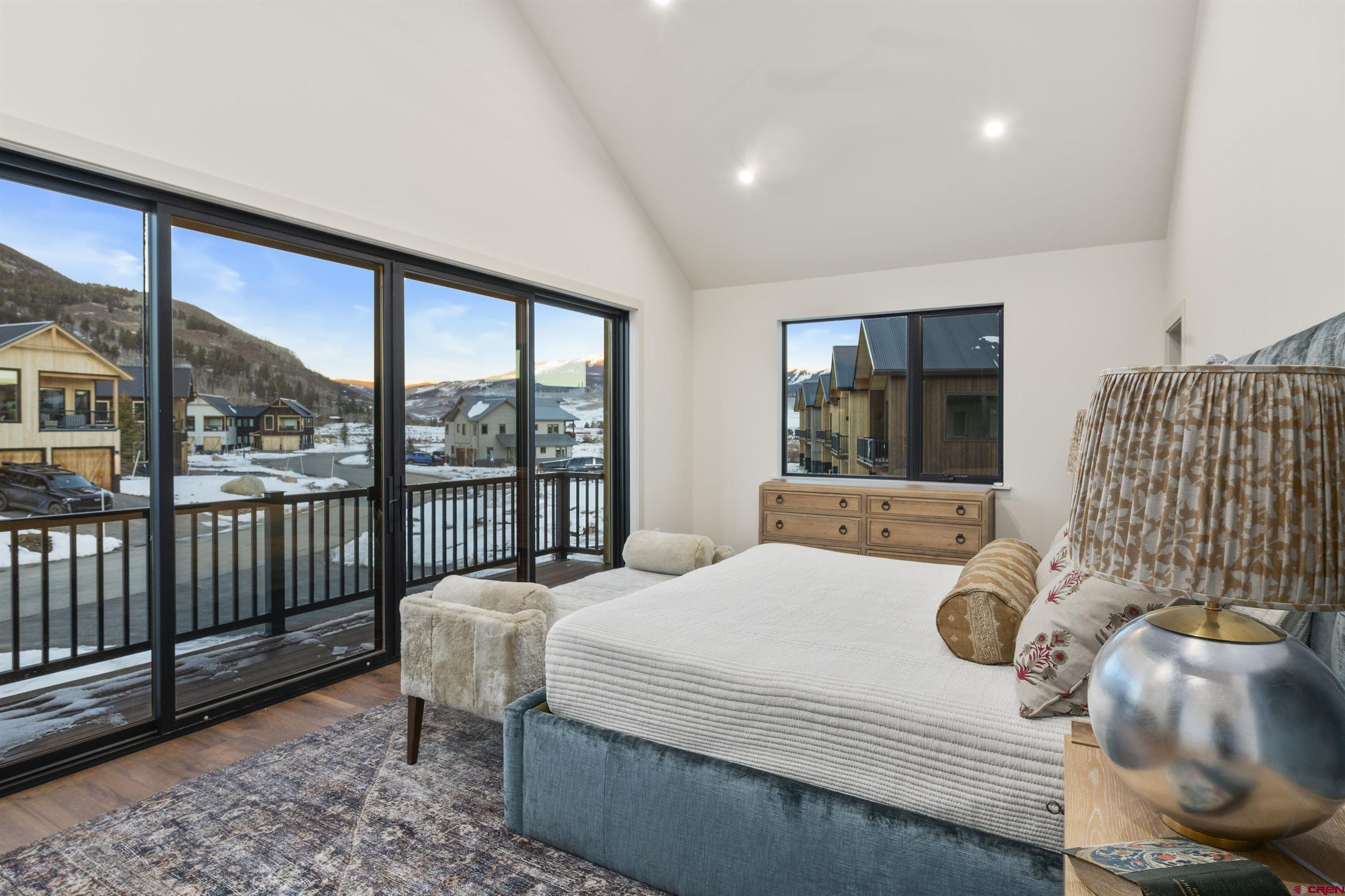 180 Elk Valley Road, Unit 118 Crested Butte, CO 81224 - Photo 19 of 39 a bedroom with a bed and glass window
