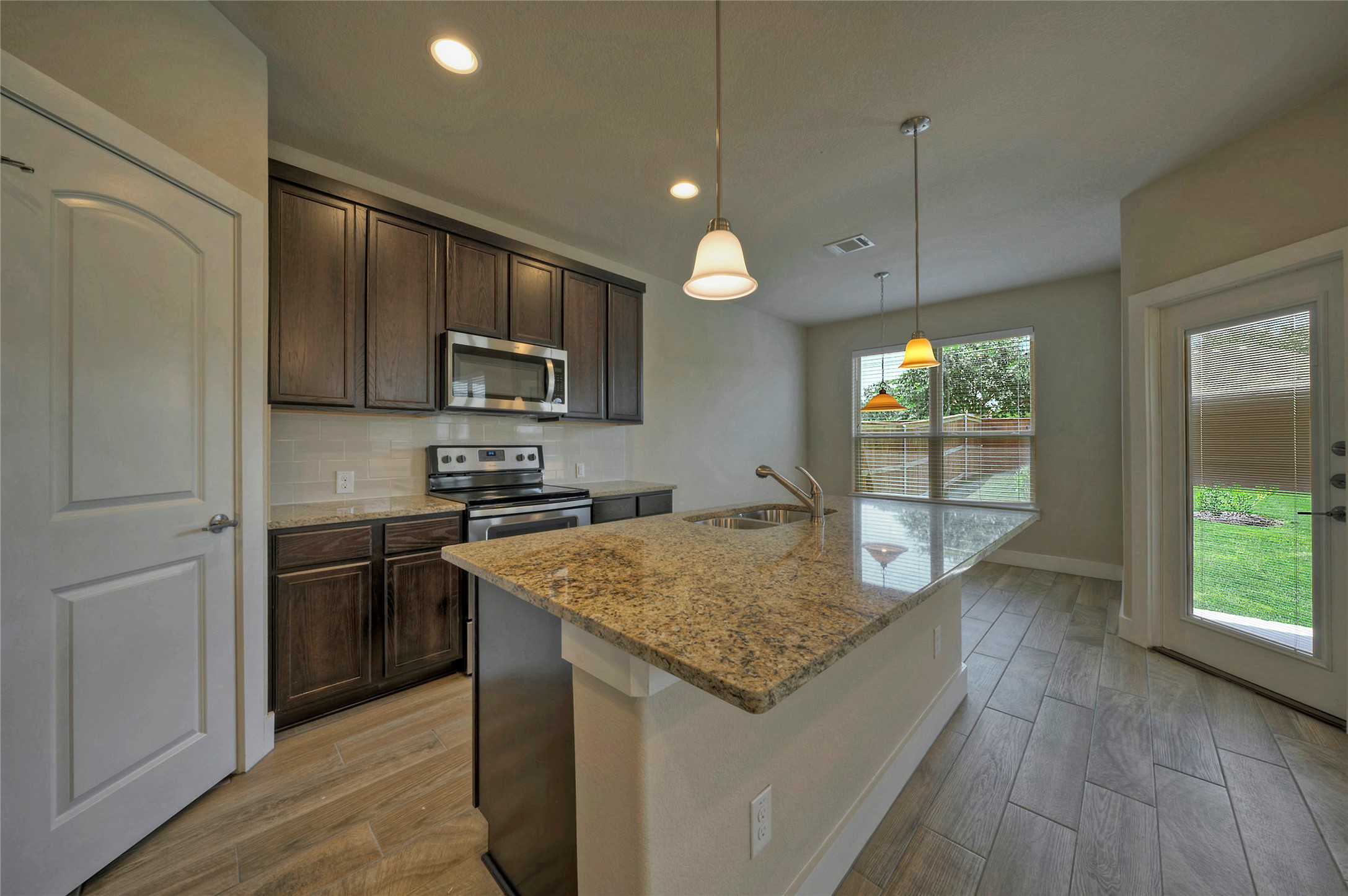 508 High Tech Drive, Unit B Georgetown, TX 78626 - Photo 4 of 24 A well-appointed kitchen showcasing a spacious island with a sink and pendant lighting.