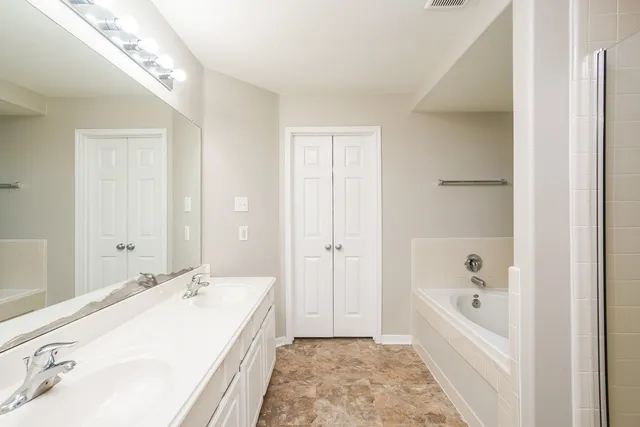 a bathroom with a tub sink and mirror