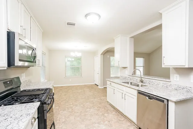 a kitchen with a sink stove and cabinets