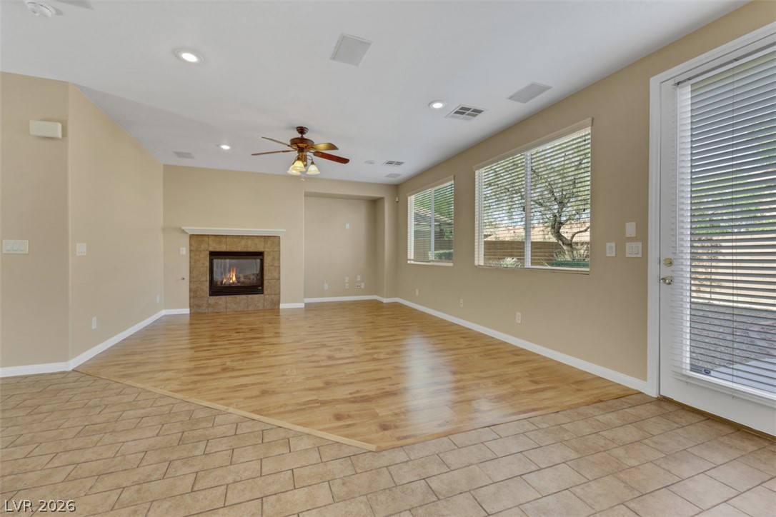 10328 Hawk Ravine Street Las Vegas, NV 89178 - Photo 7 of 55 A grand living space with mixed flooring, a warm fireplace, and ample natural light.