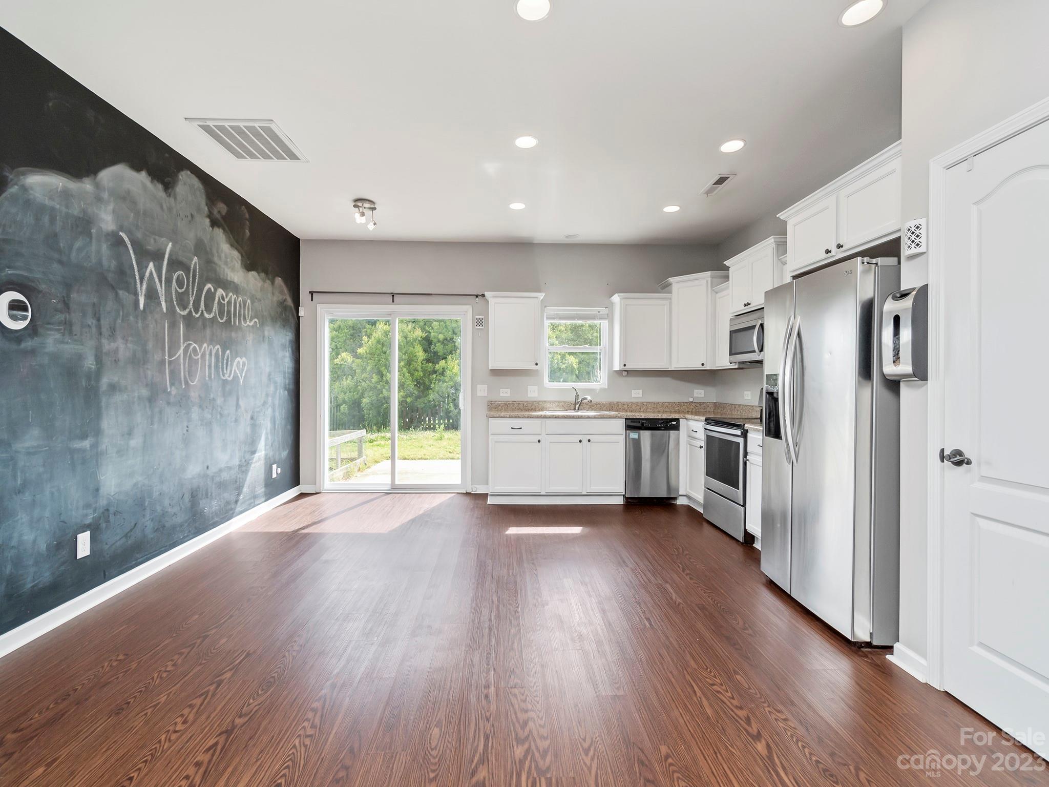 13723 Porter Creek Road Charlotte, NC 28262 - Photo 17 of 40 a kitchen with stainless steel appliances refrigerator wooden floor and window