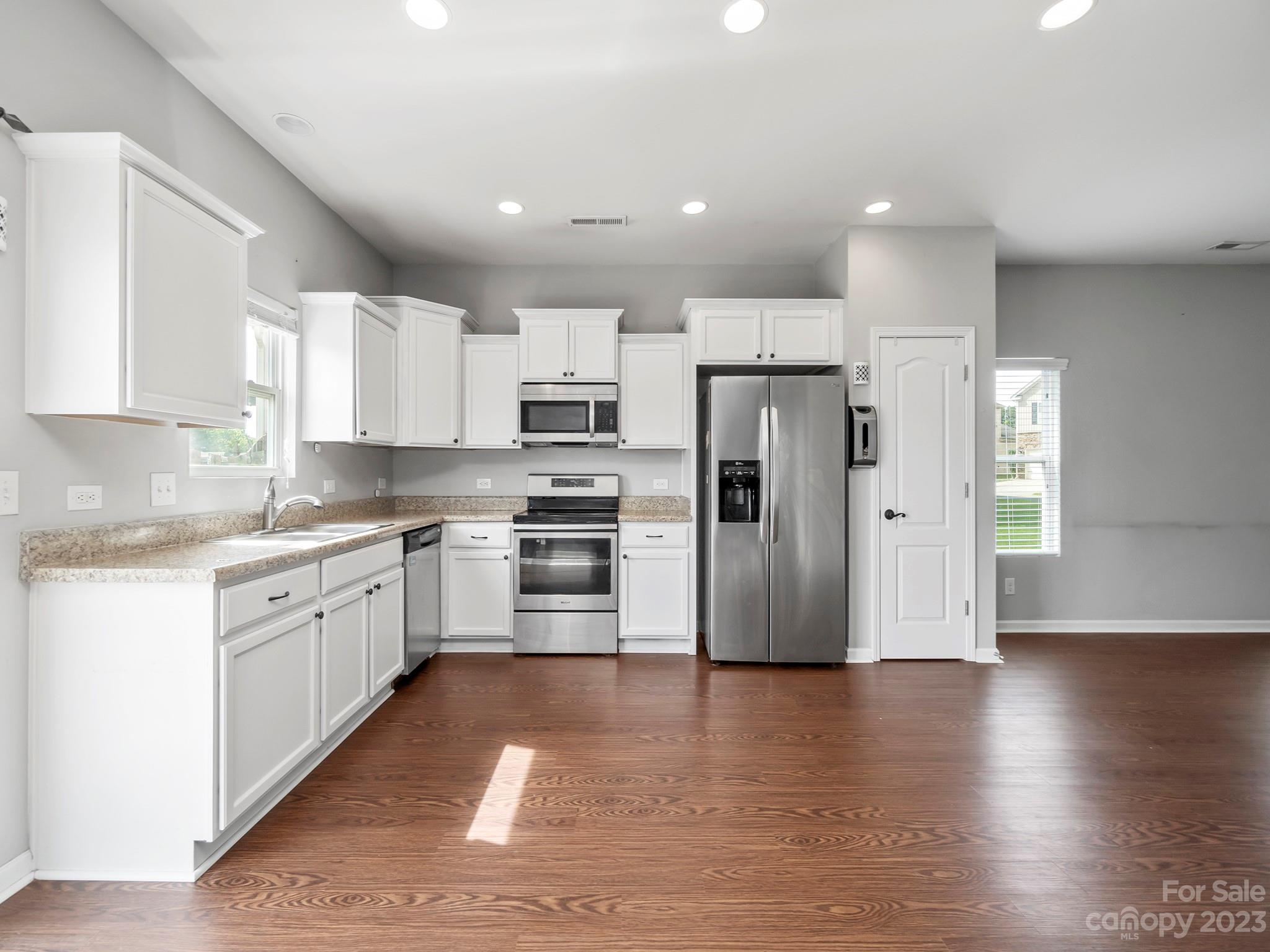 13723 Porter Creek Road Charlotte, NC 28262 - Photo 19 of 40 a kitchen with stainless steel appliances kitchen island granite countertop a refrigerator and a stove top oven