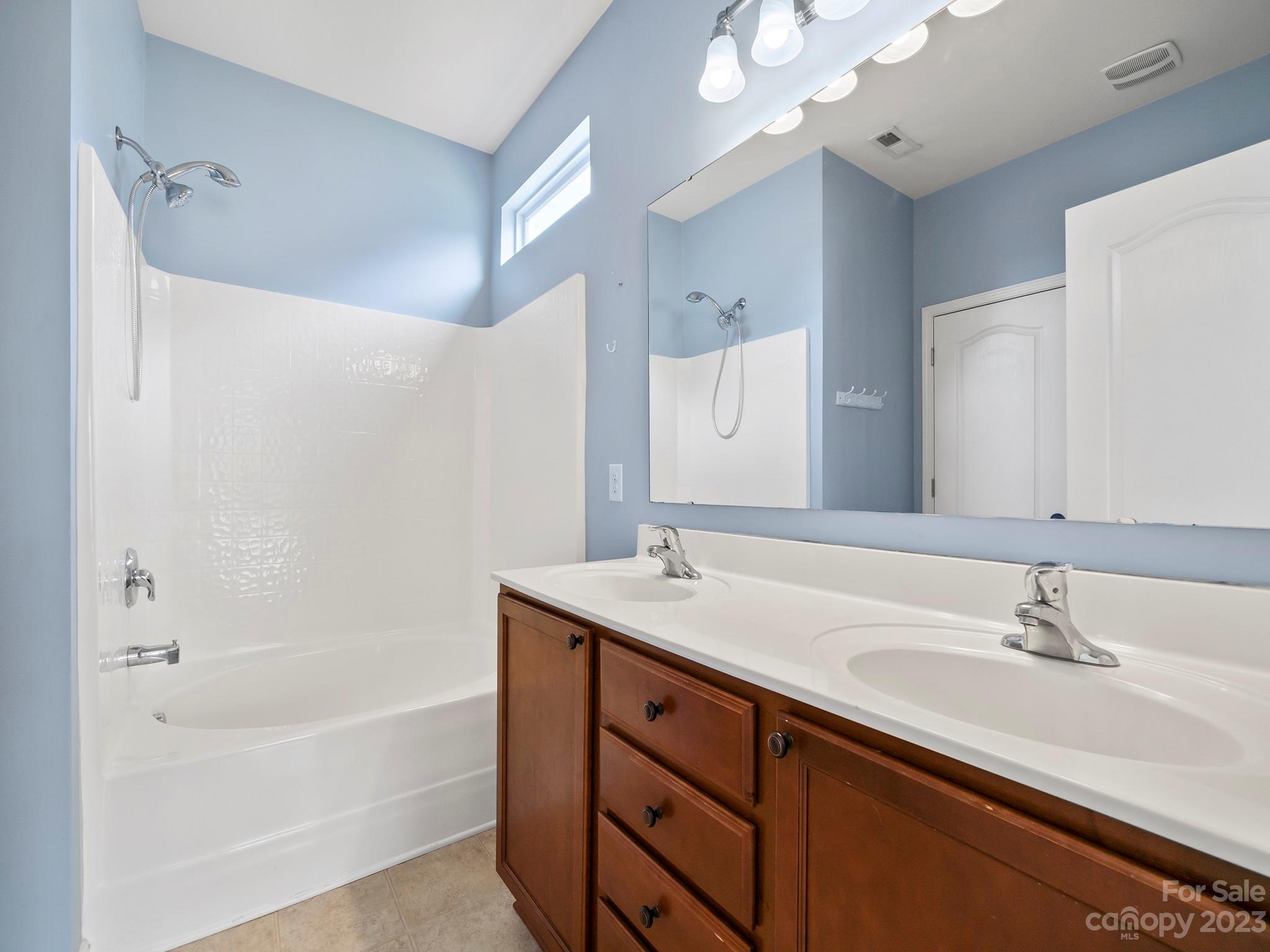 13723 Porter Creek Road Charlotte, NC 28262 - Photo 25 of 40 a bathroom with a sink double vanity granite tub and a mirror