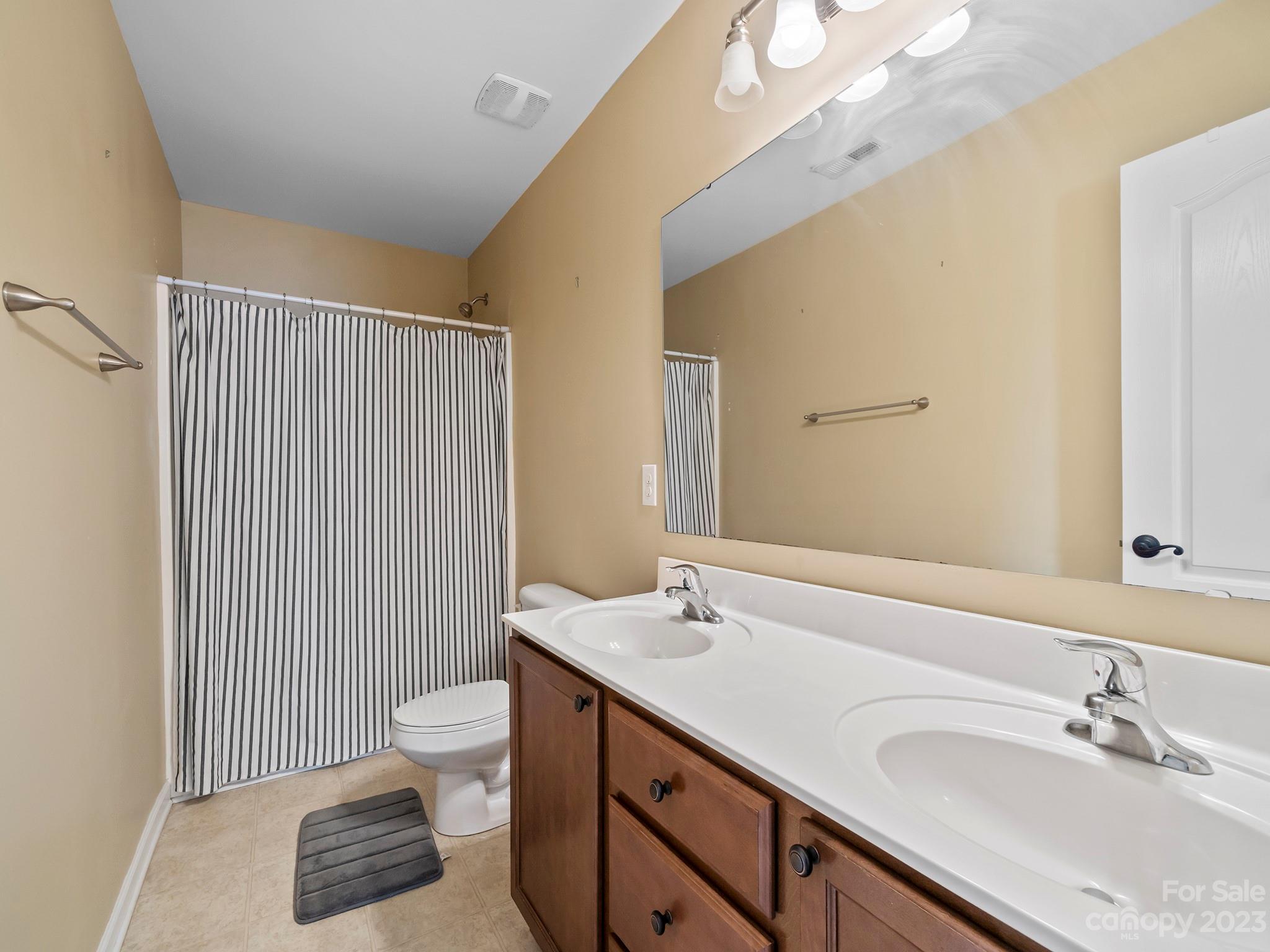 13723 Porter Creek Road Charlotte, NC 28262 - Photo 30 of 40 a bathroom with a sink a toilet and shower