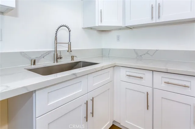 a kitchen with white cabinets and a sink