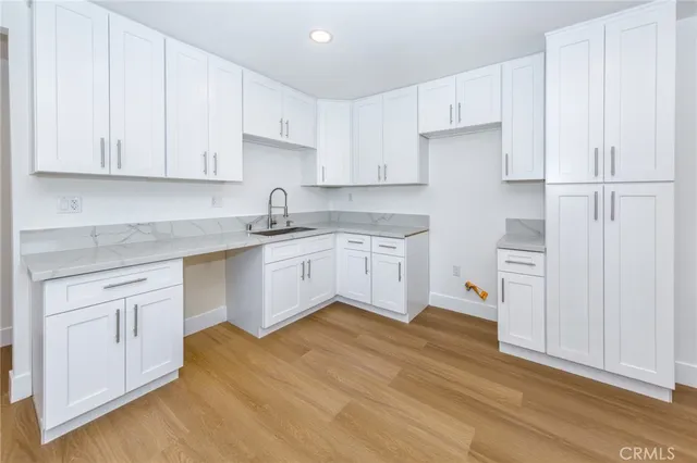 a kitchen with white cabinets sink and white appliances