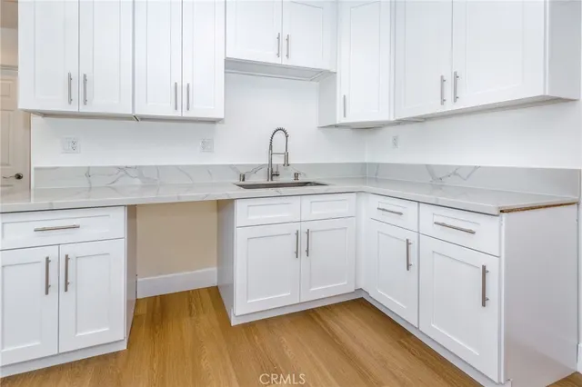 a kitchen with white cabinets appliances and a sink