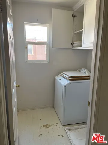 a utility room with cabinets washer and dryer