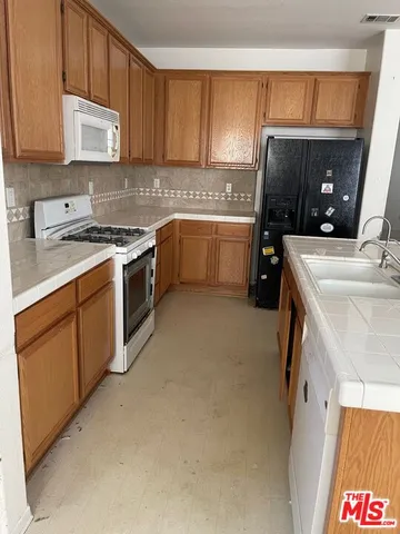 a kitchen with a stove a sink and a refrigerator