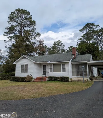 a view of a house with a big yard and large trees