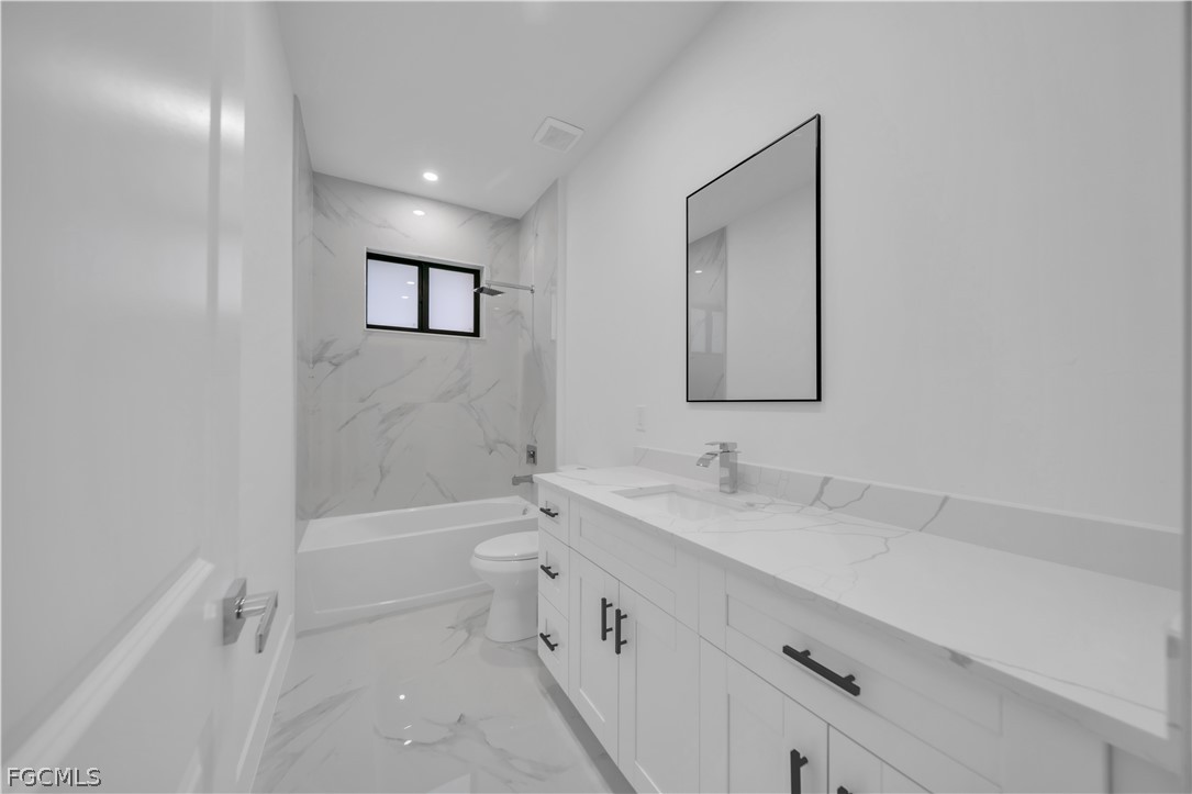 5003 2nd Street West Lehigh Acres, FL 33971 - Photo 12 of 21 a bathroom with a double vanity sink toilet mirror and bathtub