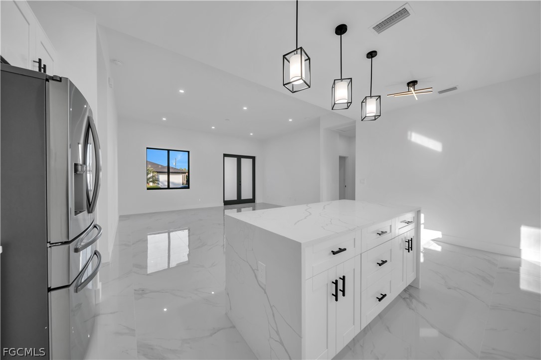 5003 2nd Street West Lehigh Acres, FL 33971 - Photo 14 of 21 a kitchen with stainless steel appliances a refrigerator a sink and a stove