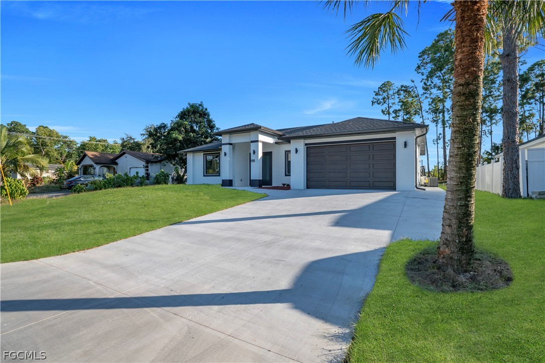 5003 2nd Street West Lehigh Acres, FL 33971 - Photo 2 of 21 a front view of a house with a yard and garage