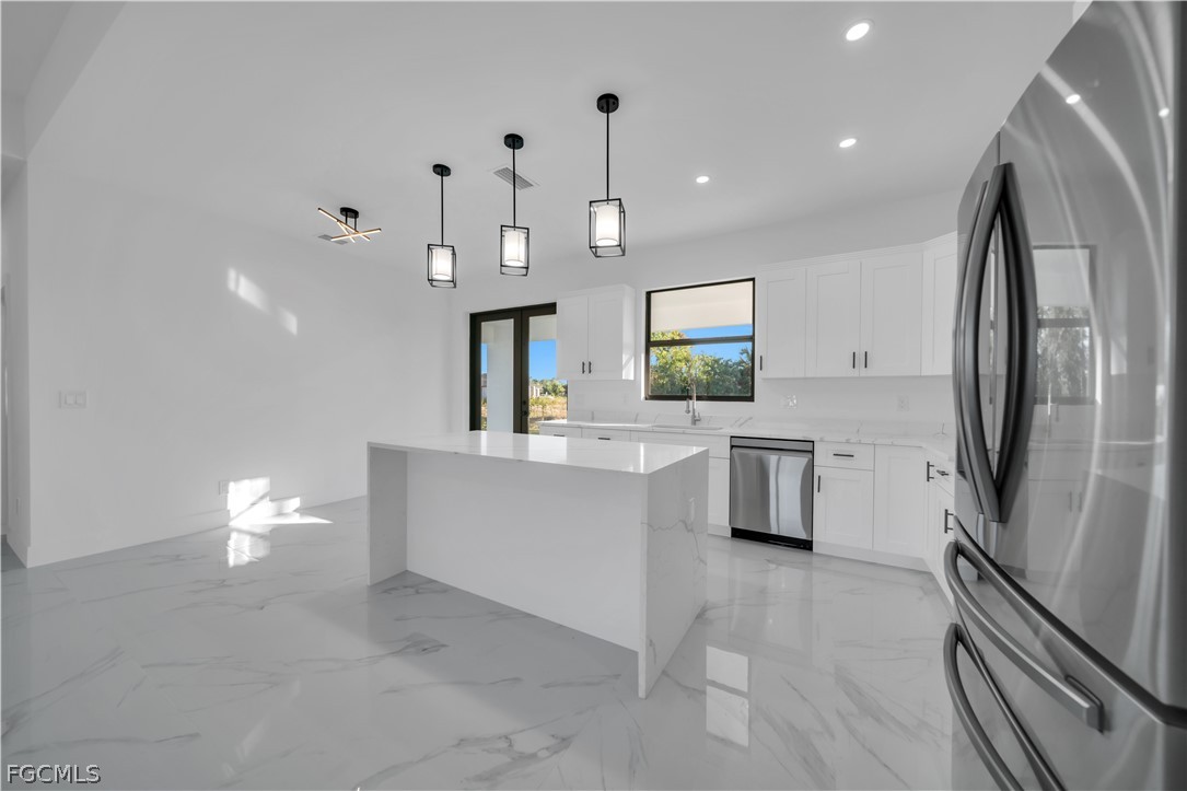 5003 2nd Street West Lehigh Acres, FL 33971 - Photo 3 of 21 a large white kitchen with a sink stainless steel appliances and cabinets