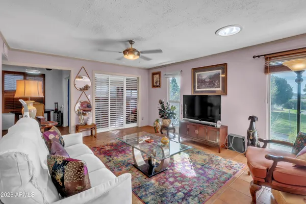 a living room with furniture flat screen tv and a large window