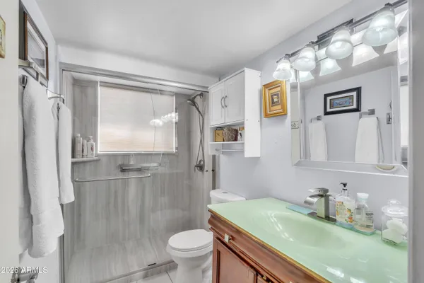 a bathroom with a granite countertop sink toilet and shower