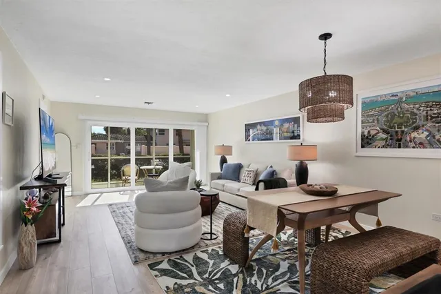 a living room with furniture a table and kitchen view