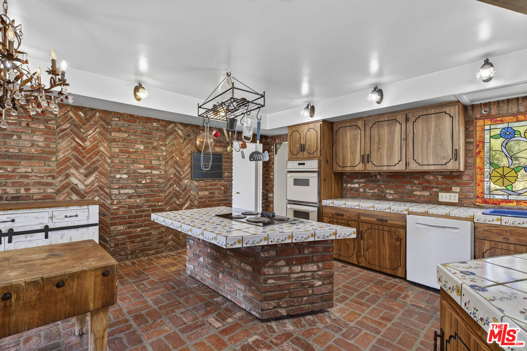 24962 Eldorado Meadow Road Hidden Hills, CA 91302 - Photo 19 of 19 a kitchen with stainless steel appliances granite countertop a stove a sink dishwasher and cabinets with wooden floor